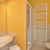 Bagno con lavabo, doccia e pareti gialle.