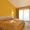 Camera con letto, TV e balcone con tende.