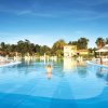 Una grande piscina all'aperto con lettini e ombrelloni.