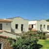 Edifici bianchi con tetti in tegole rosse immersi nel verde.