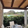 Portico con tavolo e sedie vista piscina e montagna.