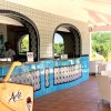 Bar con bancone in ceramica blu e sedie di vimini.