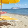 Lettini gialli sulla spiaggia con mare e ombrelloni.
