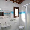 Bagno con doccia, lavabo e specchio decorato.