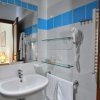 Bagno con specchio, lavabo e asciugacapelli.