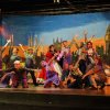 Spettacolo teatrale con artisti sul palco.