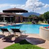 Piscina all'aperto con lettini e ombrelloni.