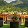 Terrazza con poltrone di vimini e vista sulle montagne.