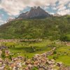 Villaggio alpino con montagne sullo sfondo.