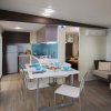 Interno moderno con cucina, tavolo apparecchiato e divano.