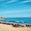 Spiaggia con lettini e ombrelloni blu.