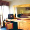 Stanza d'hotel con scrivania, specchio e letto visibile.