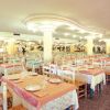 Grande sala da pranzo con tavoli apparecchiati.