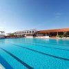 Grande piscina rettangolare all'aperto con edifici sullo sfondo.