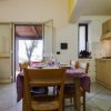 Cucina e sala da pranzo con tavolo apparecchiato, divano arancione e accesso all'esterno.