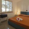 Camera da letto con letto matrimoniale arancione, due comodini con lampade accese e una finestra.