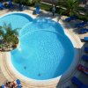 Piscina a forma di trifoglio con lettini blu intorno.