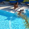 Due bambini e una donna vicino a una piscina.