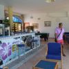 Interno di un bar in una struttura turistica, arredi moderni e un uomo che cammina.