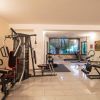 Palestra interna con attrezzi fitness, pavimento piastrellato e finestre.