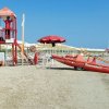 Spiaggia con torretta di salvataggio e motoscafo.