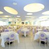 Ristorante con tavoli apparecchiati e sedie color lavanda.