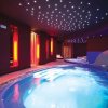Piscina interna con luci a soffitto e atmosfera rilassante.