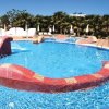 Piscina con scivolo e fontana centrale colorata.