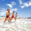 Bambini che corrono in mare su una spiaggia.