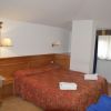 Camere d'hotel con letto matrimoniale e decorazioni in legno.