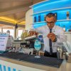 Barista prepara un cocktail blu al bar della piscina.