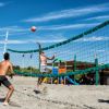 Persone che giocano a beach volley su una spiaggia.