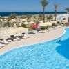Piscina con vista mare, ombrelloni e palme.