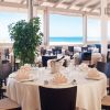 Ristorante elegante con tovaglie bianche e vista sul mare.