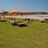 Lettini e ombrelloni arancioni vicino a una piscina.