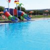Piscina con scivoli colorati e sdraio.