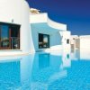 Edificio bianco con piscina a sfioro azzurra.