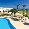 Piscina circondata da ombrelloni e vista mare.