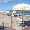 Spiaggia sabbiosa con ombrelloni di paglia.