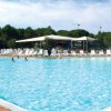 Grande piscina all'aperto con sedie a sdraio e ombrelloni.