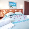 Letto con cuscini azzurri e petali rosa.