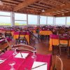 Sala da pranzo con tavoli apparecchiati.