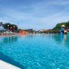 Piscina con scivoli e ombrelloni rossi.