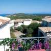 Vista mare e case dal balcone fiorito.