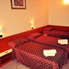 Camera d'albergo con tre letti singoli.