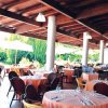 Ristorante all'aperto con tavoli apparecchiati.