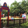 Parco giochi per bambini con recinto in legno e cartello 