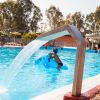 Piscina con fontana, persona su gonfiabile blu.