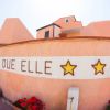 Edificio arancione con stelle e fiori rossi.