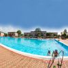 Una piscina con ombrelloni e persone che nuotano.